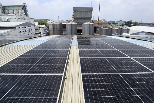 Solar PV System on Factory Roof with Silo Background