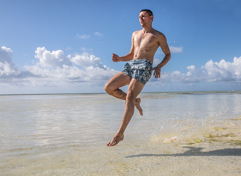 man running on tropical beach