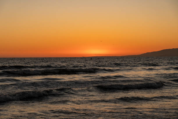 sonnenuntergang und die wellen am strand - venice california santa monica pier sunset beach stock-fotos und bilder