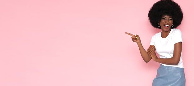 Beautiful model with an afro hairstyle on a pink background.