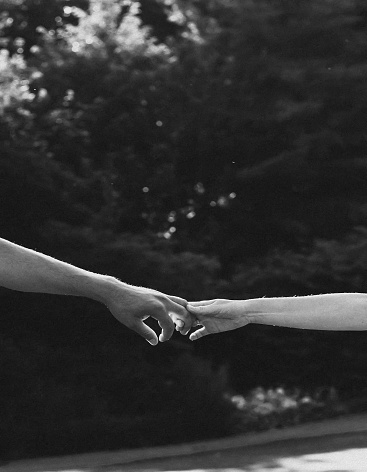 Emotional black and white photo of breakdown in the relationship between two people. Black and white photo of two hands at the moment of breakup. The concept of break up.