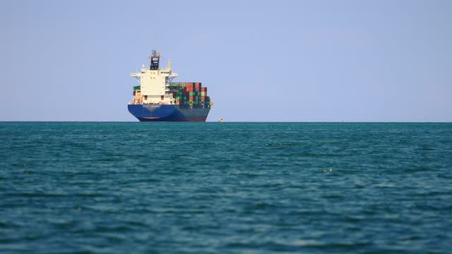 SLO MO Container Ship Sails along Slovenian Coast, framed by the Mesmerizing Blue Sky and Horizon