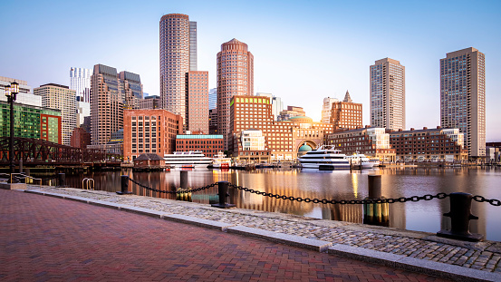The Boston Harbor and Financial district in Boston, Massachusetts, USA at sunrise showcasing its mix of contemporary and historic buildings.