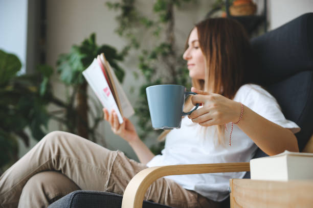istock Woman reading book and drinking coffee 1503382641