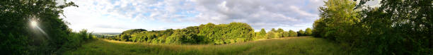 High Resolution and High Angle Ultra Wide Panoramic View of British Countryside Landscape During Just Before Sunset. The Footage Was Captured at Sharpenhoe Clappers Luton, Bedfordshire England UK on June 24th, 2023 with Drone's Camera.