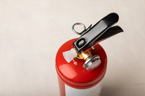 Fire extinguisher on a light texture background. Fire protection, home fire extinguisher. home security concept. Place for text. Copy space.banner