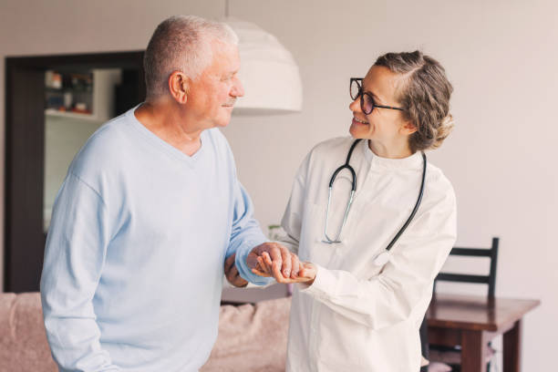 istock Female professional doctor showing medical test result explaining prescription using clipboard visiting senior elderly old man patient at home sitting on sofa 1503392221