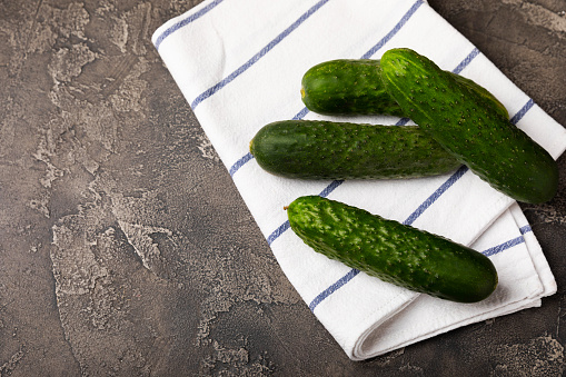 Fresh organic cucumbers against on the table. Cucumber slices. Salad ingredient. Fresh vegetables. Vegan food. Healthy food. Fresh organic vegetables.