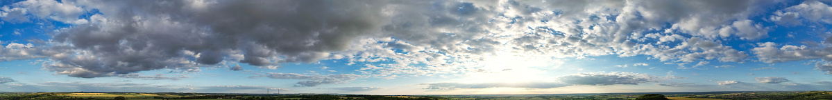 High Resolution and High Angle Ultra Wide Panoramic View of Clouds over British Countryside Landscape During Just Before Sunset. The Footage Was Captured at Sharpenhoe Clappers Luton, Bedfordshire England UK on June 24th, 2023 with Drone's Camera.