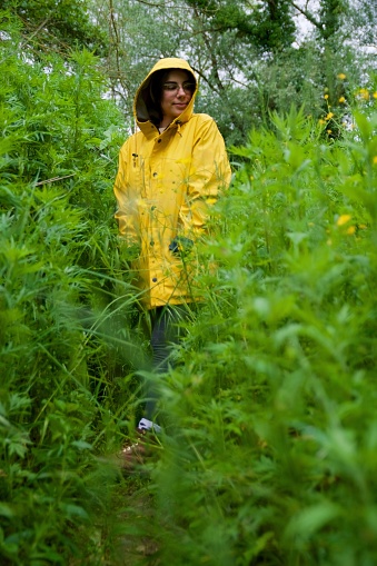 Girl enjoy nature in a rainy day with yellow raincoat, outdoor people lifestyle