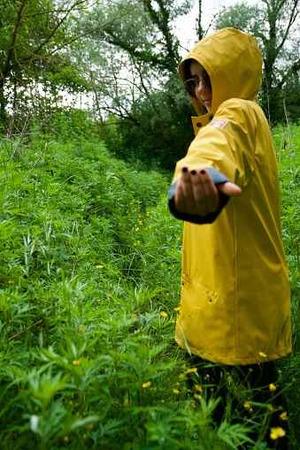 Girl enjoy nature in a rainy day with yellow raincoat, outdoor people lifestyle