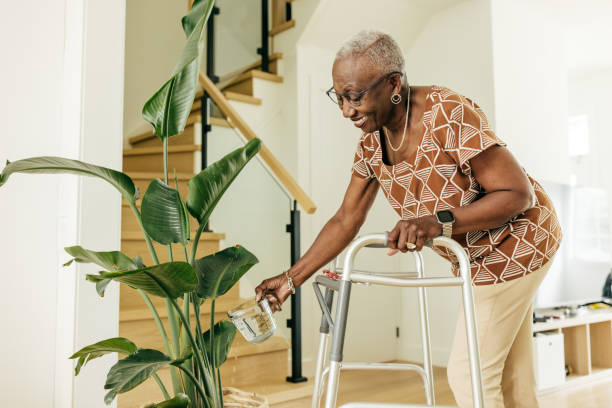 istock Senior women with nice flexibility watering the plant at home while using a walker 1503398450