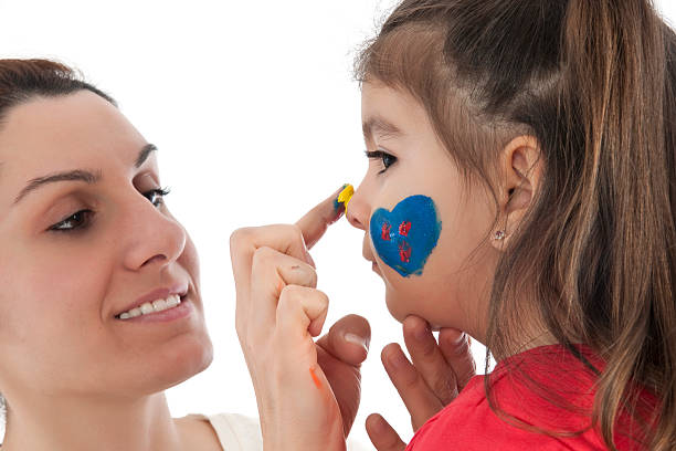 istock mother painting daughter's face 150339881