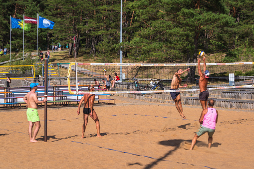 Saulkrasti, Latvija - June 25, 2023: Men play volleyball on the beach