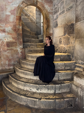 Woman is sitting on the stairs  at the Church of the Holy Sepulchre in old city of Jerusalem