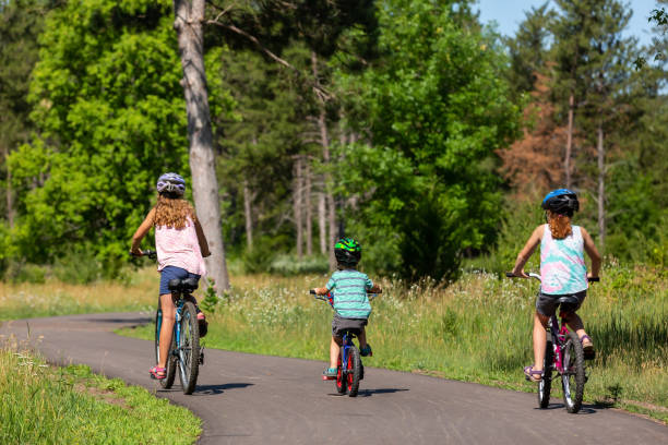 istock Three Children Riding Bike on Paved Trail Through Woods 1503400891