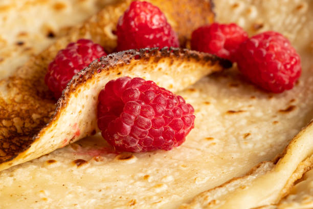 Thin pancakes with raspberries close-up, dessert and breakfast