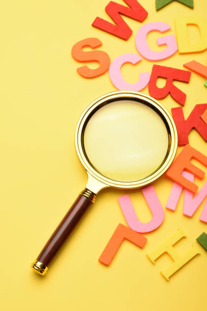 istock Multi colored alphabet letters and magnifying glass on the yellow background 1503421042