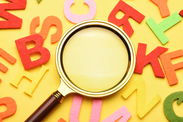 istock Multi colored alphabet letters and magnifying glass on the yellow background 1503421090