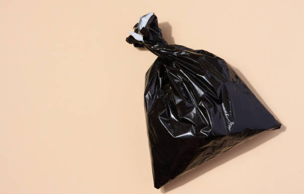 istock Full black plastic bag on a beige background, top view 1503437701