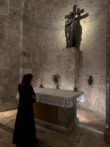 Woman is praying at the Church of the Holy Sepulchre in old city of Jerusalem