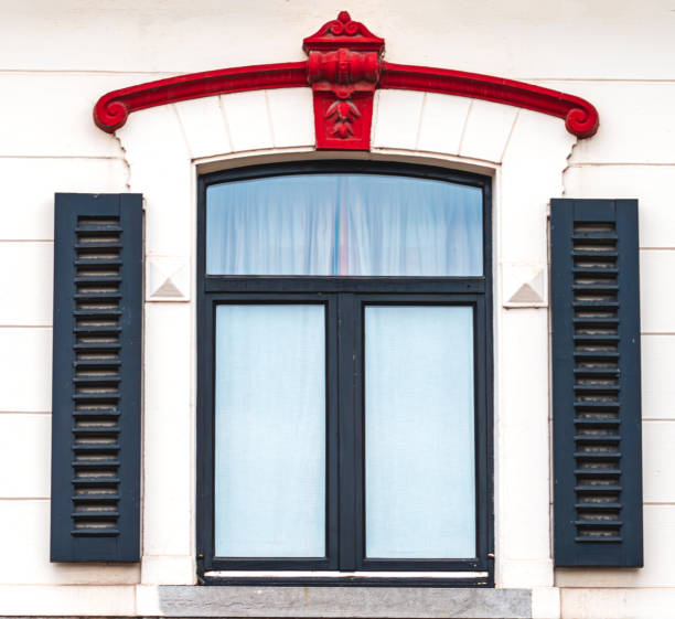 window on a white wall, a window with a black frame and shutters, a red cornice above the window,architecture texture,rustic window