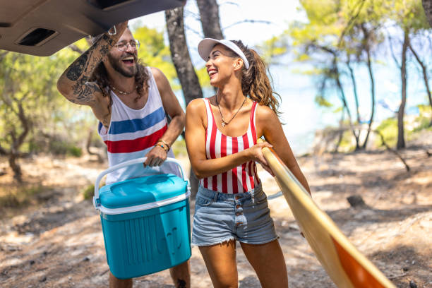 paar, das sich für den strand fertig macht - cool-pack stock-fotos und bilder