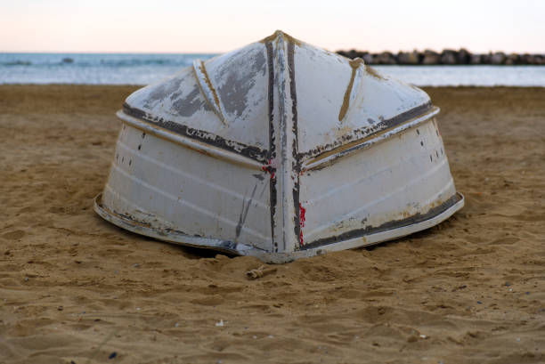 Abandoned boat on a quiet Croatian beach with weathered wood and soft tide