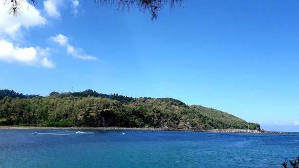 istock Beautiful background of Widara Payung Beach Cilacap Central Java with green hill and blue sky for wallpaper 1503454728