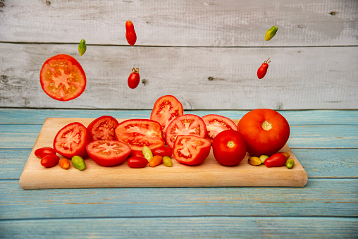 Glasses with tomato juice, tomatoes and spices on wooden background