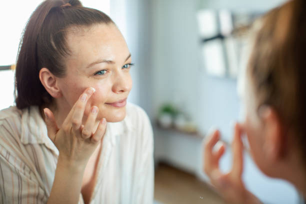 istock Young woman putting on makeup while looking in a mirror at home 1503457230