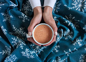 holding a cup of hot chocolate