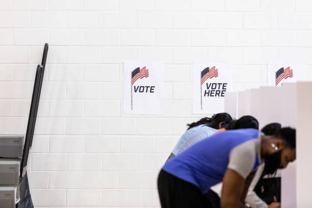 istock Unrecognizeable voters stand at the polls to make their selections 1503484160