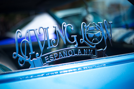 Santa Fe, NM: A lowrider motto (LOVING LOW) in the window of a blue lowrider car parked on the historic Santa Fe Plaza on the annual (June) Lowrider Day.