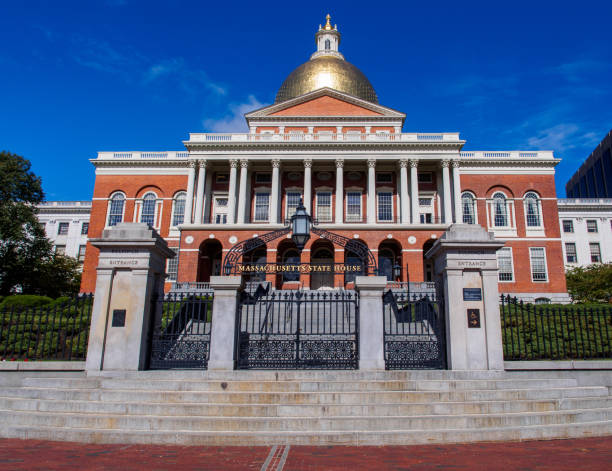 massachusetts state house or  capitol building, in central boston, with its red brick facade and golden dome or cupola against a blue sky. - boston massachusetts massachusetts state capitol state capitol building imagens e fotografias de stock