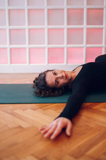 istock Smiling girl lying on the mat and stretching while looking at the camera. 1503534317
