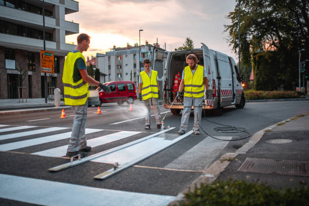 straßenbauarbeiter besprühen einen zebrastreifen - construction safety mid adult men road construction stock-fotos und bilder