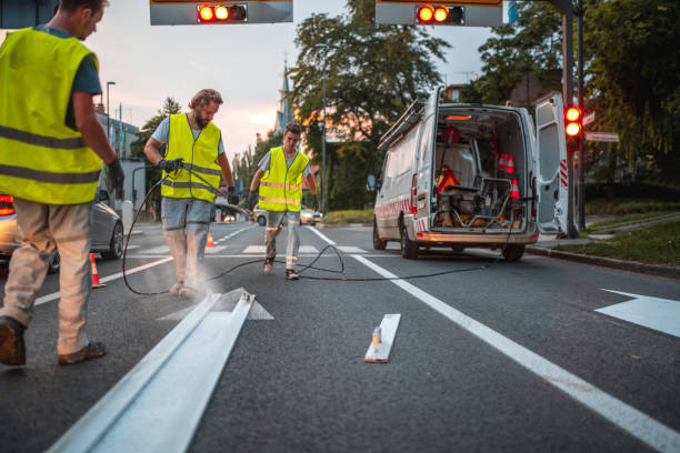 istock Group Of Workers Repainting A Pointy Arrow Road Sign 1503534845