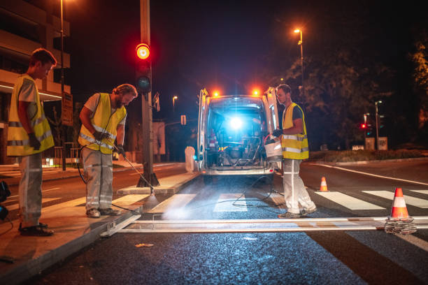 istock Construction Workers Spray Painting A Crosswalk With A Spray Gun 1503534875