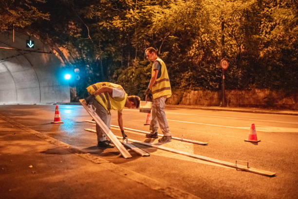 squadra di manutenzione stradale che prepara un segnale stradale a destra per la verniciatura - construction safety mid adult men road construction foto e immagini stock