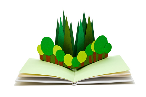 Close up of trees in a pop-up picture book, isolated on white. (The paper craft in the book was made by myself.)