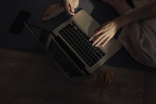 High angle view of hands of woman typing on laptop and exercising during home workout on mat