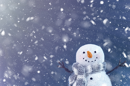 Cheering happy snowman in the majestic snowfall. Copy space allows this image to be used for any winter design concepts such as Christmas card, new year card, invitation, storytelling, background, advertisement and marketing. Not AI