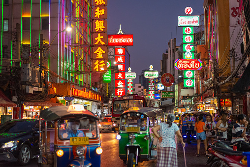 Bangkok, Thailand - March 27, 2023: night Yaowarat Road with Chinese signboards, street traffic and walking crowd.