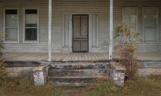 The weathered porch of an abandoned house in rural Alabama