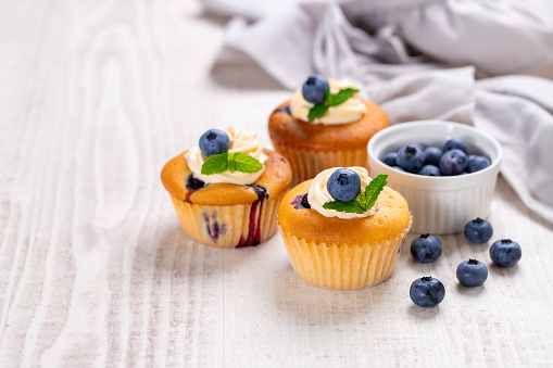 Blueberry cupcakes decorated with vanilla cream
