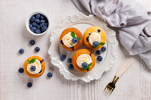 Blueberry cupcakes decorated with vanilla cream