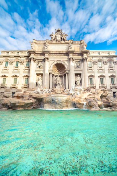 baixo ângulo do exterior da fonte de trevi com fachada incrível, arquitetura e esculturas na cidade velha com água limpa sob o céu nublado, roma, itália - trevi fountain rome fountain monument - fotografias e filmes do acervo