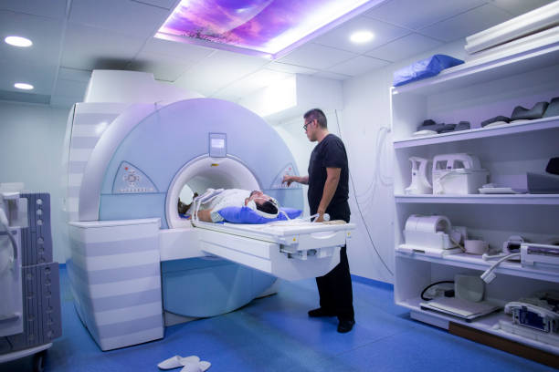 mann unterzieht sich einer mrt-untersuchung in einem krankenhaus - magnetresonanztomographie stock-fotos und bilder