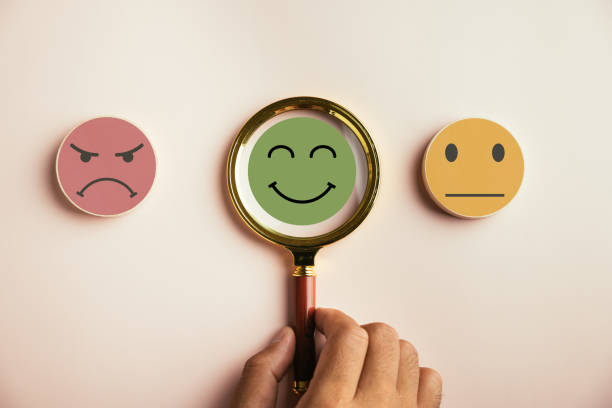 istock Magnifier in hand focuses on selected happy smiley face icon 1503645389